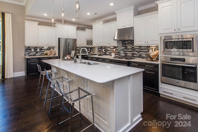 kitchen with white cabinets, a kitchen island with sink, stainless steel appliances, and sink