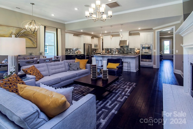 living room with ornamental molding, a chandelier, sink, and dark hardwood / wood-style flooring