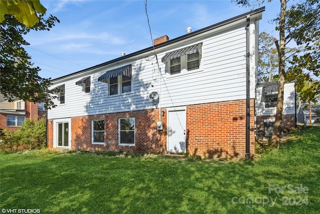 rear view of house with a yard