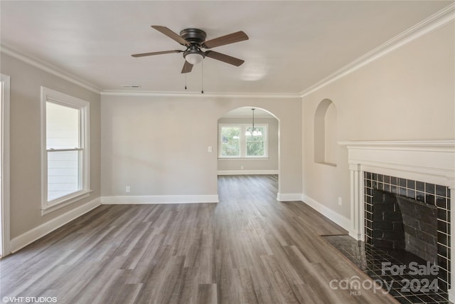 unfurnished living room featuring ornamental molding, wood-type flooring, and a tile fireplace