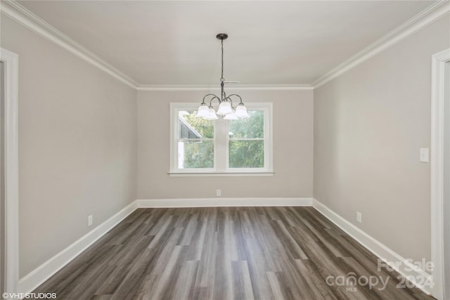 spare room featuring crown molding, dark hardwood / wood-style flooring, and an inviting chandelier