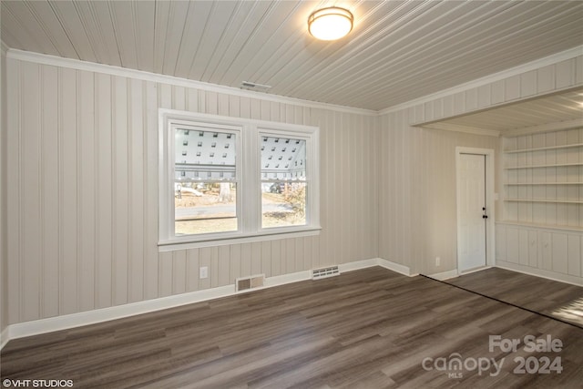 unfurnished room with ornamental molding, dark wood-type flooring, and wood ceiling