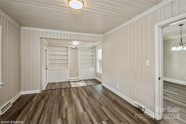 interior space with dark hardwood / wood-style flooring, crown molding, a chandelier, and built in shelves