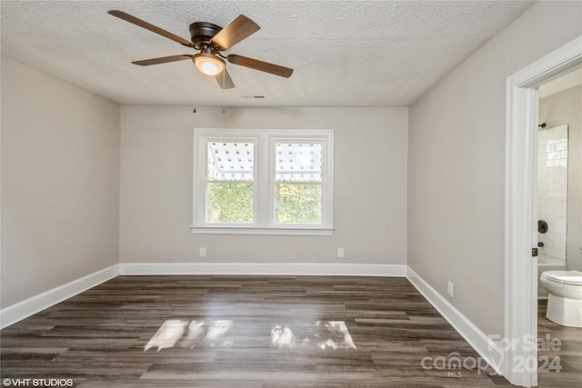 empty room with a textured ceiling, dark wood-type flooring, and ceiling fan