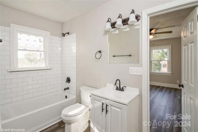 full bathroom featuring vanity, tiled shower / bath combo, toilet, and wood-type flooring