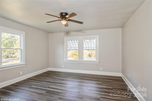 spare room with a wealth of natural light, dark hardwood / wood-style floors, and ceiling fan