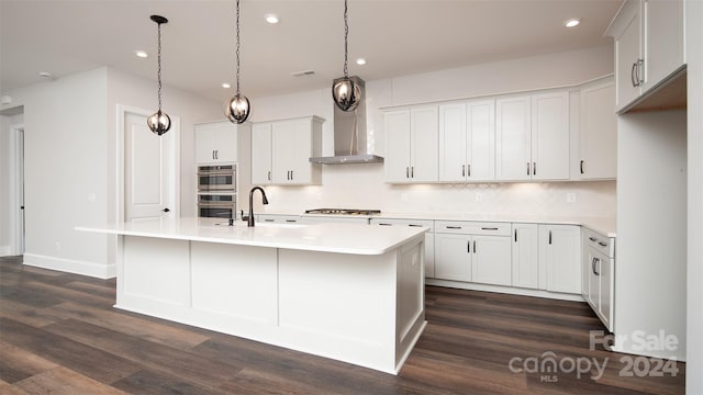 kitchen featuring an island with sink, appliances with stainless steel finishes, and dark hardwood / wood-style flooring