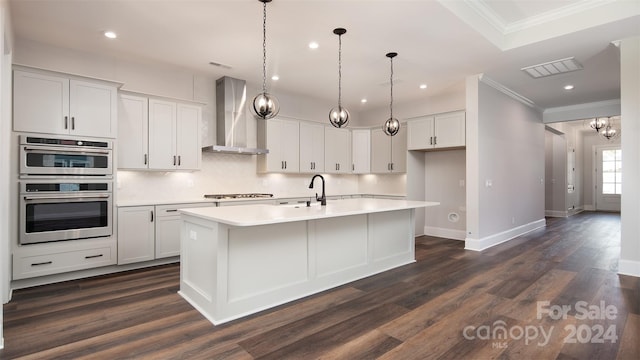 kitchen with wall chimney range hood, white cabinets, a kitchen island with sink, and dark hardwood / wood-style floors