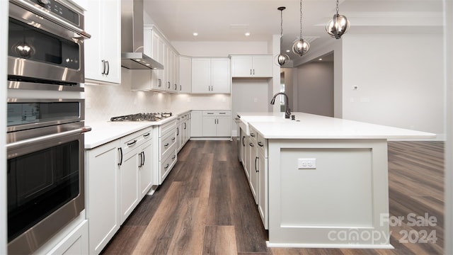 kitchen featuring white cabinets, an island with sink, dark wood-type flooring, and wall chimney exhaust hood