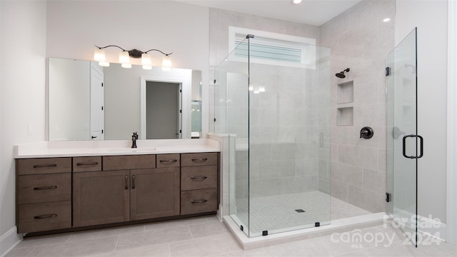 bathroom with vanity, tile patterned floors, and a shower with door