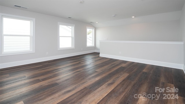 spare room with lofted ceiling and dark hardwood / wood-style flooring