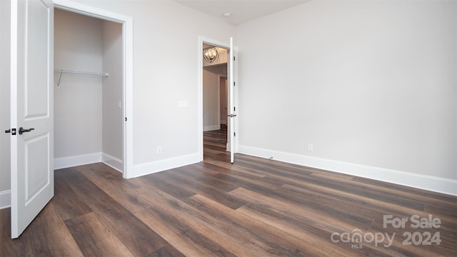 unfurnished bedroom with a closet and dark wood-type flooring