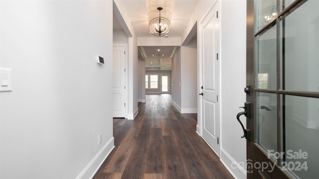 hall featuring dark hardwood / wood-style floors and a notable chandelier