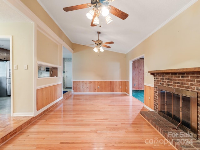 unfurnished living room with light hardwood / wood-style floors, lofted ceiling, and ornamental molding