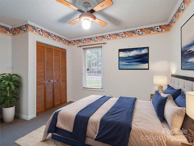 bedroom featuring a textured ceiling, ornamental molding, carpet floors, a closet, and ceiling fan