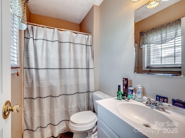 bathroom featuring a shower with curtain, vanity, a textured ceiling, and toilet