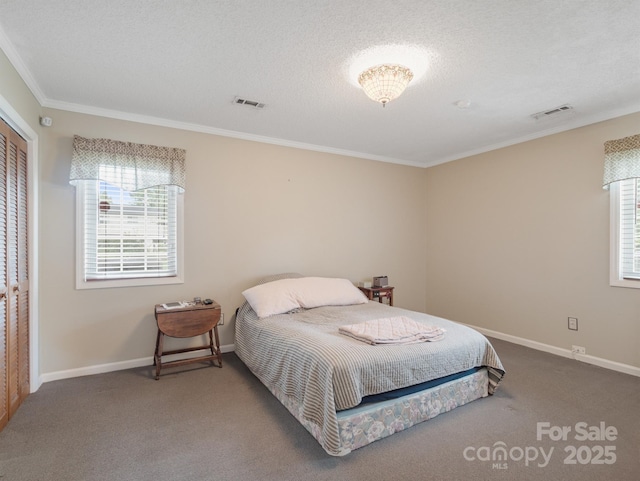 bedroom featuring crown molding, carpet floors, and a textured ceiling