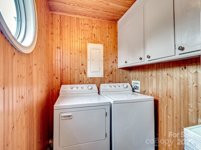 washroom with wooden walls, cabinets, electric panel, wood ceiling, and washing machine and dryer