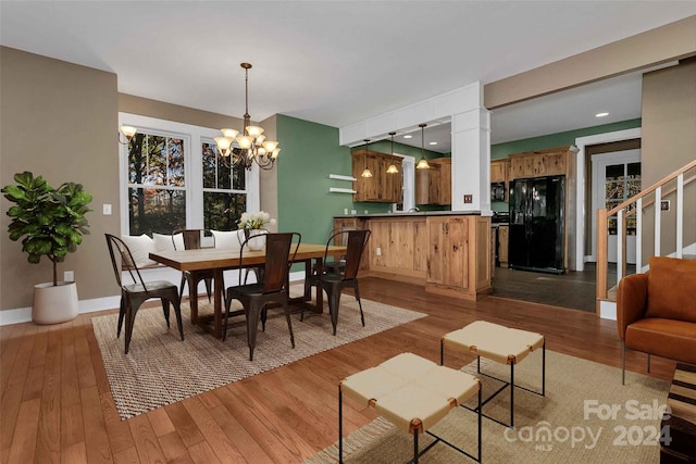 dining space featuring hardwood / wood-style floors and an inviting chandelier