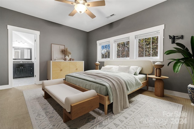 bedroom with connected bathroom, ceiling fan, and light hardwood / wood-style flooring