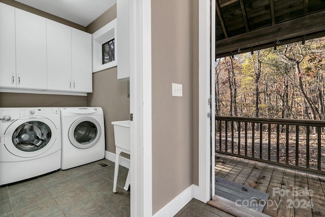 clothes washing area with light tile patterned flooring, cabinets, and independent washer and dryer