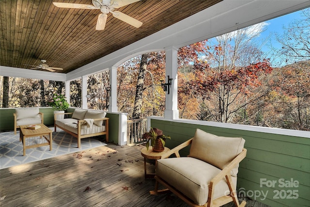 wooden terrace with an outdoor living space and a ceiling fan