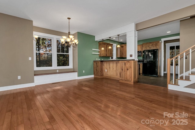 interior space with stairway, an inviting chandelier, baseboards, dark wood-style flooring, and visible vents