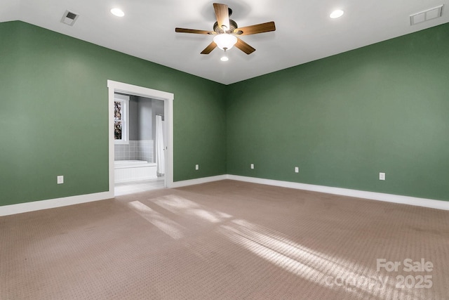 spare room with baseboards, a ceiling fan, visible vents, and carpet floors