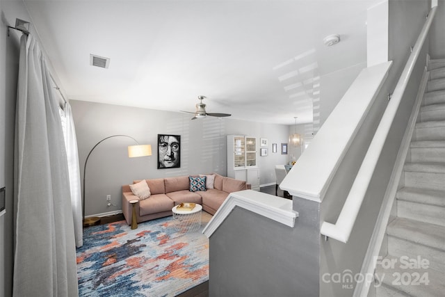 living room with ceiling fan with notable chandelier