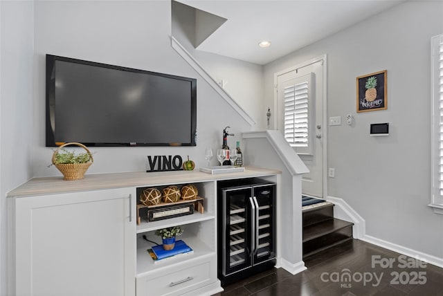 bar with white cabinets, dark hardwood / wood-style floors, and beverage cooler