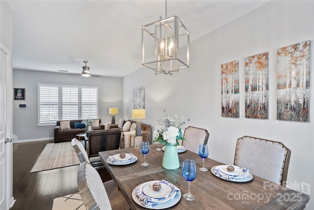 dining area with wood-type flooring and ceiling fan with notable chandelier