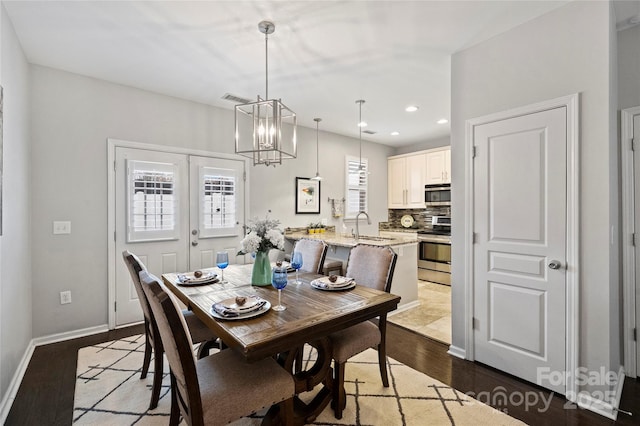 dining area featuring french doors, a notable chandelier, dark hardwood / wood-style floors, and a wealth of natural light