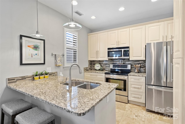 kitchen featuring pendant lighting, sink, a breakfast bar area, appliances with stainless steel finishes, and kitchen peninsula