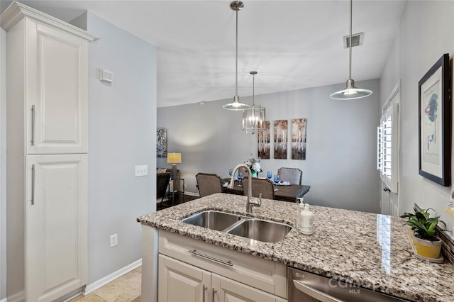 kitchen with sink, light stone counters, stainless steel dishwasher, pendant lighting, and white cabinets