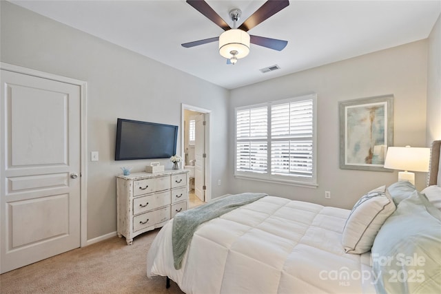 carpeted bedroom with ceiling fan and ensuite bathroom