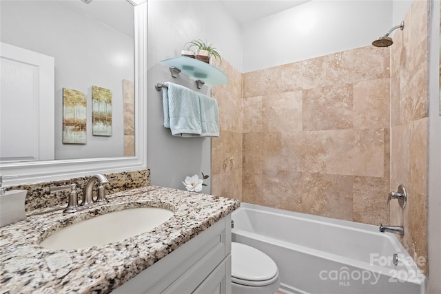 full bathroom featuring tiled shower / bath, vanity, and toilet