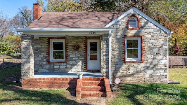 view of front of property with a porch and a front lawn