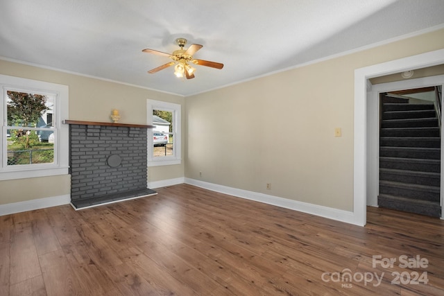 unfurnished living room with plenty of natural light, dark hardwood / wood-style flooring, and crown molding