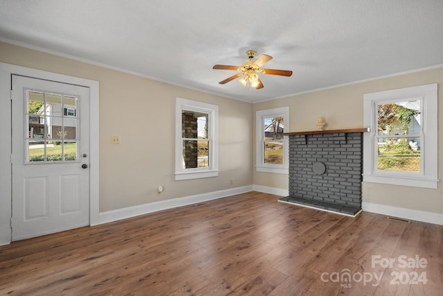 unfurnished living room featuring a textured ceiling, dark hardwood / wood-style flooring, ceiling fan, and crown molding