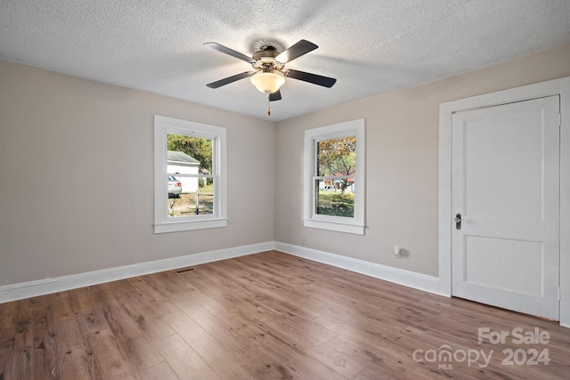 unfurnished bedroom featuring hardwood / wood-style flooring, ceiling fan, and a textured ceiling