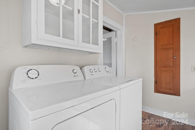 laundry room with cabinets, independent washer and dryer, crown molding, and dark wood-type flooring