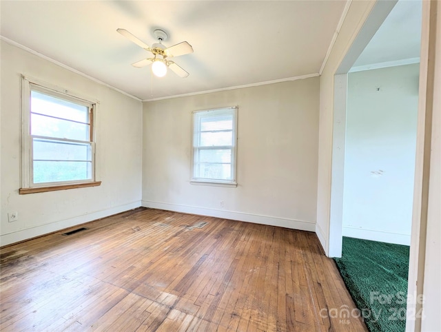 empty room with ornamental molding, hardwood / wood-style floors, and a healthy amount of sunlight