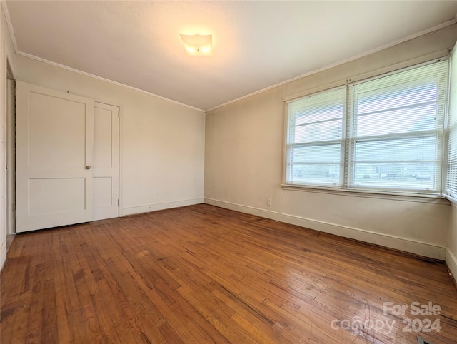 unfurnished bedroom featuring wood-type flooring and ornamental molding