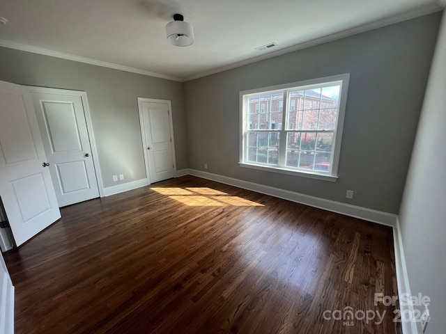 unfurnished bedroom with ornamental molding and dark hardwood / wood-style flooring