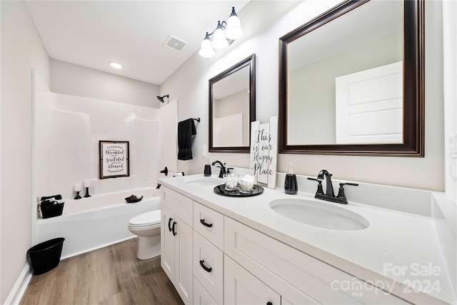 full bathroom with vanity, toilet, hardwood / wood-style flooring, and shower / bathing tub combination