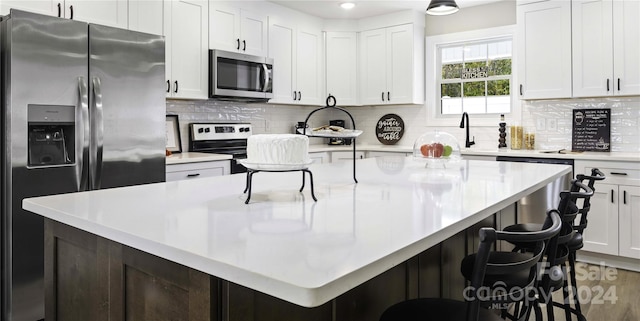 kitchen featuring a kitchen bar, stainless steel appliances, and backsplash