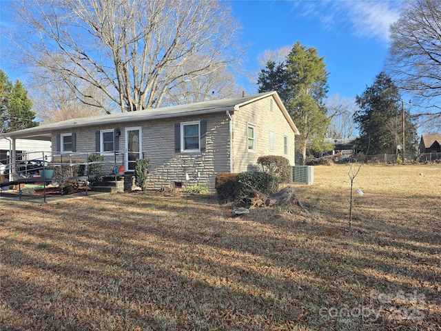 view of front facade with a wooden deck and a front lawn