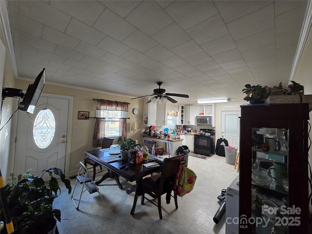 dining space with ornamental molding and ceiling fan