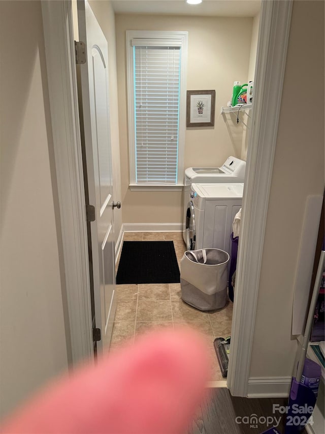 clothes washing area featuring washing machine and dryer and light tile patterned flooring