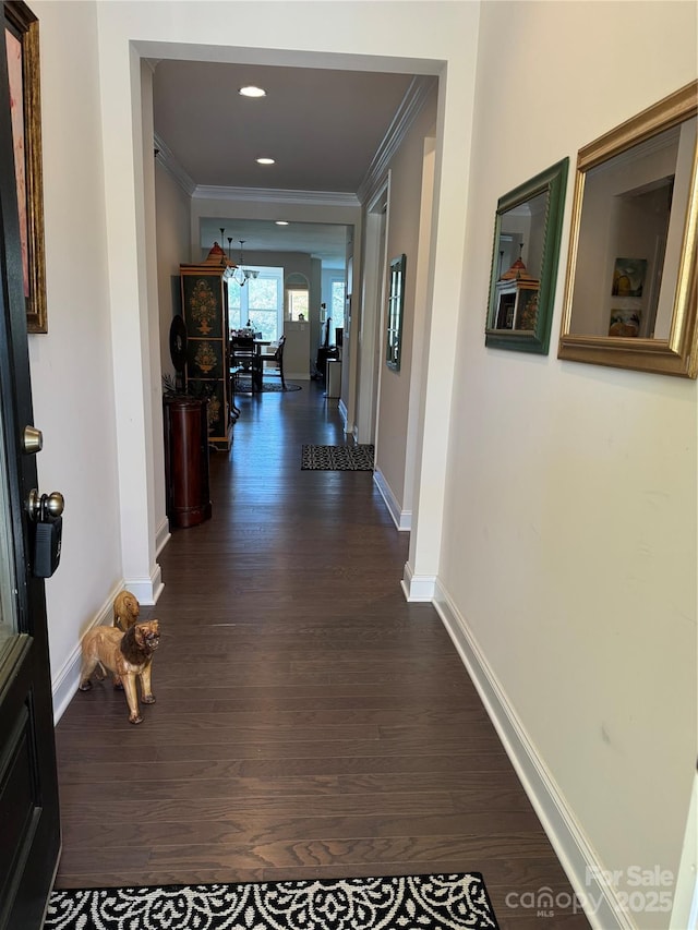 corridor featuring crown molding, dark wood-style flooring, baseboards, a chandelier, and recessed lighting
